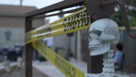 Halloween Decorations of a Skull and Caution Tape on a Rusty Well Stock Footage 219963755