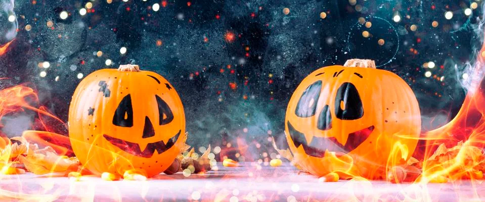 Halloween festive composition with smiling pumpkins guards, fire and smoke on Stock Photos