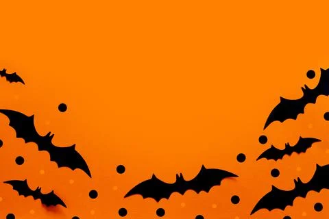 Halloween flat lay composition of black paper bats and pumpkins on orange Stock Photos