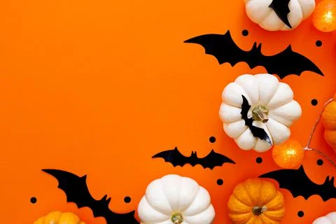 Halloween flat lay composition of black paper bats and pumpkins on orange Stock Photos
