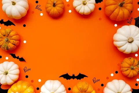 Halloween flat lay composition of black paper bats and pumpkins on orange Stock Photos