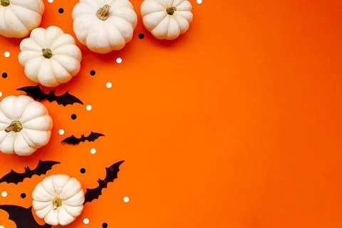 Halloween flat lay composition of black paper bats and pumpkins on orange Stock Photos