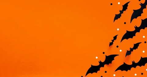 Halloween flat lay composition of black paper bats and pumpkins on orange Stock Photos