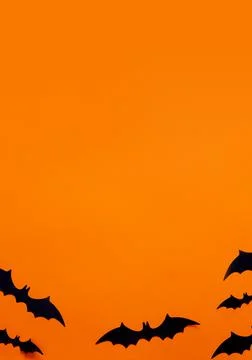 Halloween flat lay composition of black paper bats and pumpkins on orange Stock Photos