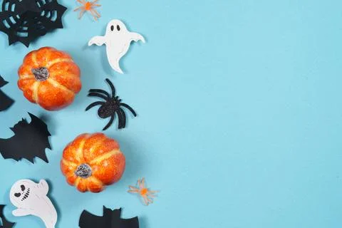 Halloween flat lay concept with pumpkins ghosts bats and spiders on blue Stock Photos
