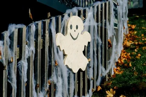 Halloween Ghost Decoration Draped in Webbing on Wooden Fence in Fall Garden.. Stock Photos