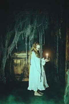 Halloween. A ghost girl in a nightgown wanders through the old house at night Stock Photos