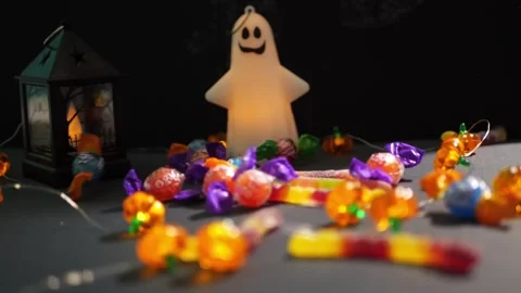 Halloween ghost light and pumpkin lights with candy on dark table 스톡 동영상 342520432