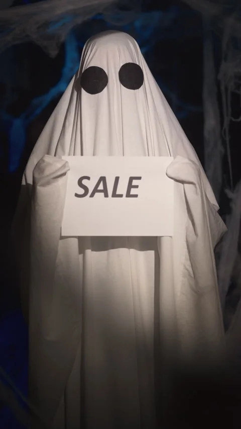 Halloween ghost in white sheet in dark corridor with spider web holding paper Stock Footage 313735381