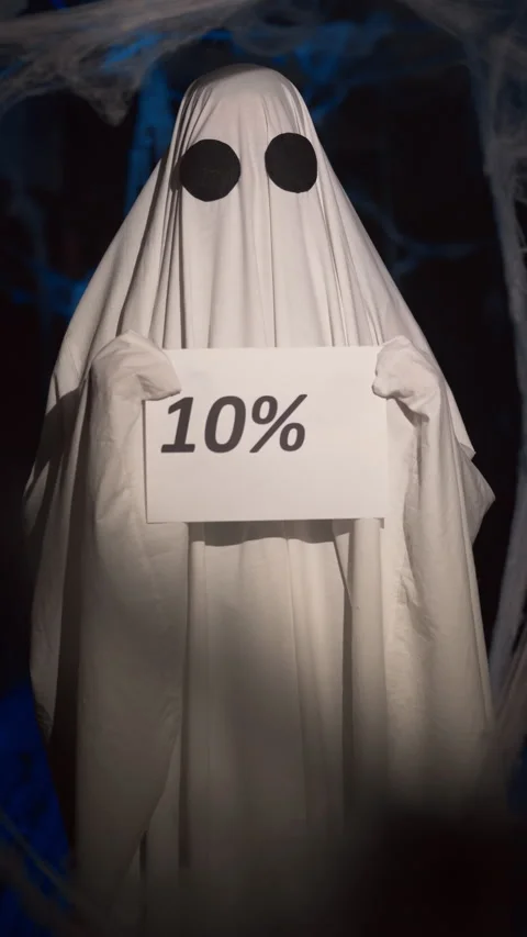 Halloween ghost in white sheet in dark corridor with spider web holding paper Stock Footage 313948017