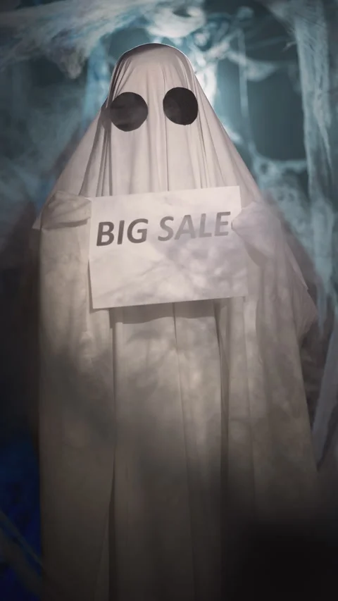 Halloween ghost in white sheet in dark corridor with spider web holding paper Stock Footage 314183142