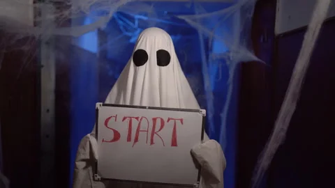 Halloween ghost in white sheet showing marker board with text Start. positive Stock Footage 314111846