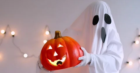 Halloween happy funny white ghost robe costume man dancing holding pumpkin 库存影片 316781853