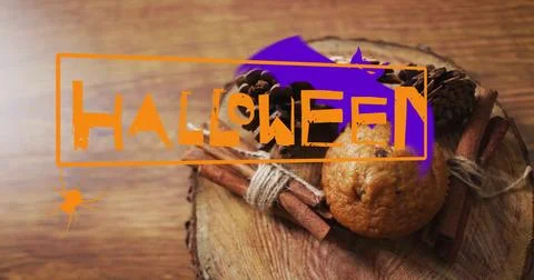 Halloween happy text image over muffin and cinnamon sticks on wooden surface Ilustração Stock