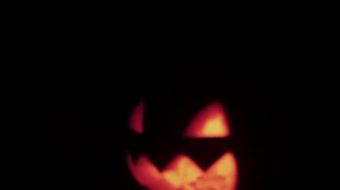 Halloween Jack o lantern with burning candle floats in dark space of alley Stock Footage 68174910