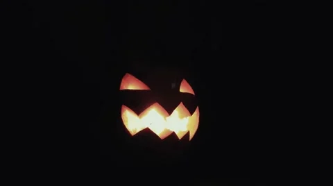 Halloween Jack o lantern with burning candle on a table in dark kitchen 4k Stock Footage 68313287