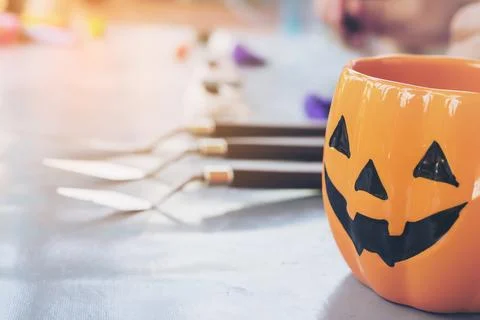 Halloween jack o lantern face mug over blurred boy sculpturing clay toy bac.. Stock Photos