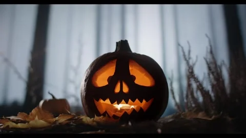 Halloween Jack O Lantern Glowing with Candlelight on a Bed of Dry Autumn Leaves 库存影片 331110391