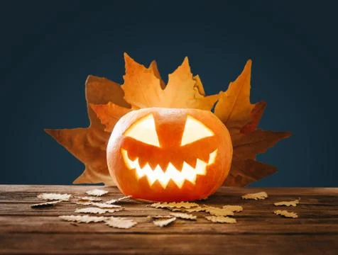 Halloween lighting jack-o-lantern pumpkin and autumn leaves. Stock Photos