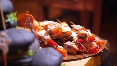 Halloween party snacks featuring grilled chicken skewers and black burgers Vidéo 336808224