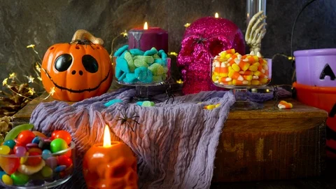Halloween party table with candy, pumpkins and skeleton candles. Stock Footage 116145009