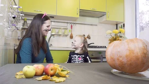 Halloween preparation. Mom does makeup to her little daughter. Sitting in the 스톡 동영상 113972712