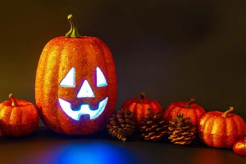Halloween pumpkin face with a light inside   surrounded by ornaments  Stock Photos