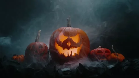 Halloween pumpkin on fire glowing inside in the dark. Scary Pumpkin with smoke a Stock Footage 252270431
