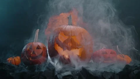 Halloween pumpkin on fire glowing inside in the dark. Scary Pumpkin with smoke a Stock Footage 252270467