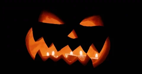 Halloween pumpkin head jack lantern with burning candles over black background Stock Footage 80137537