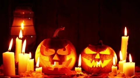 Halloween pumpkin head jack lantern with burning candles over black background Video stock 81005118