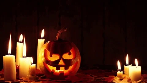 Halloween pumpkin head jack lantern with burning candles over black background Video stock 81005131