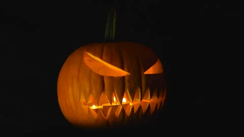 Halloween pumpkin Jack o Lantern with a scary face carved and candles burning Stock Footage 315490852