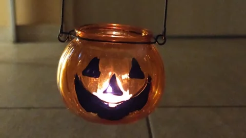 Halloween pumpkin lantern in the hands of a man with a candle swaying in the sem Видео 319695582