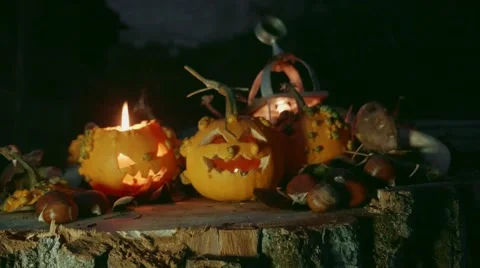Halloween pumpkin over a tree trunk with pumpkins decoration slide shot Video stock 55850017