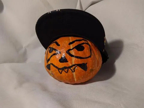 Halloween pumpkin in a snapback cap on a white background Foto stock