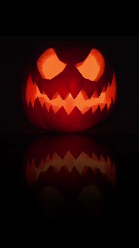 Halloween pumpkin spooky face with candle light on black background. Stock Footage 288450153