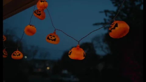 Halloween Pumpkin String Lights Glowing Against a Dark Blue Evening Sky 库存影片 331110440