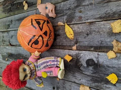 Halloween pumpkin together with a gang of scary toys on an old wooden backgro Stock Photos