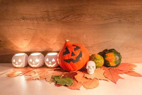 Halloween pumpkins, burning squash shape lanterns, skull-shaped toy, and dry  Stock Photos