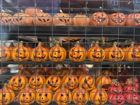 Halloween pumpkins with smiling faces on store shelf seasonal autumn decora.. Stock Photos