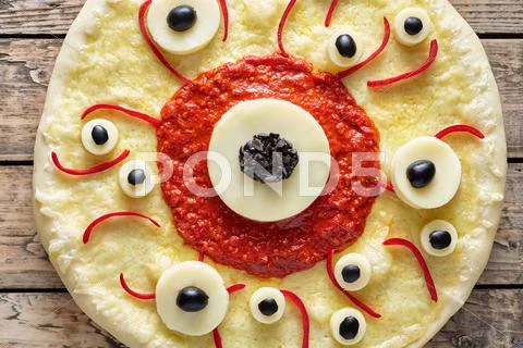Halloween scary food funny eye monster pizza with mozzarella and tomato sauce Stock Photos