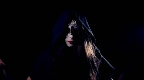 Halloween scary girl casting a spell in hood Stock Footage
