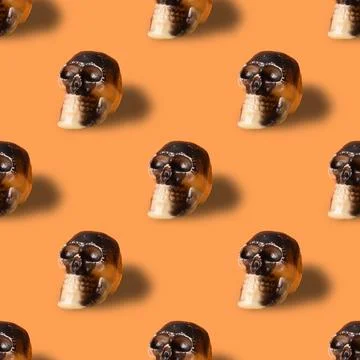 Halloween seamless pattern of skull on orange background. Stock Photos