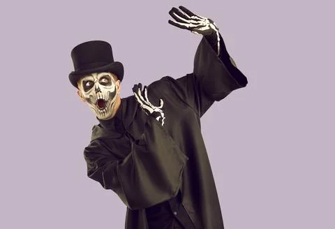 Halloween skeleton guy does protecting gesture and looks away with scared face Stock Photos