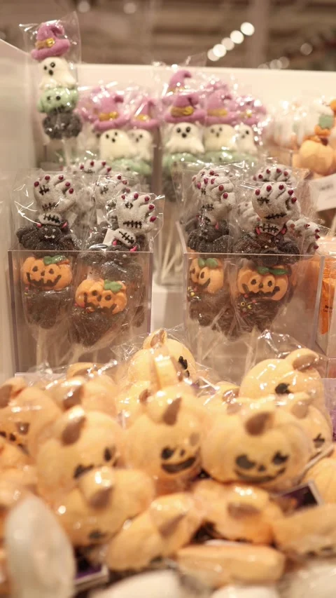 Halloween skull pumpkin ghost and witch hat sweets fill festive bakery display Stockbeeldmateriaal 345598770