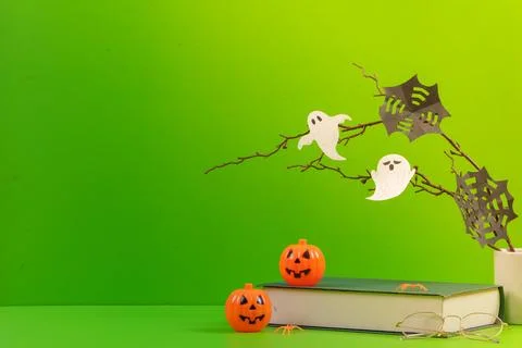 Halloween study and reading concept with paper ghosts book and pumpkins on green Stock Photos