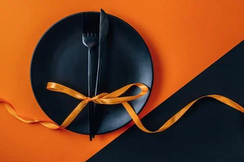 Halloween table setting with an empty black plate and cutlery a black and o.. Stock Photos