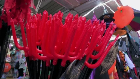 Halloween theme devil pitchfork costume accessories are being sold at a Stock Footage 164035192