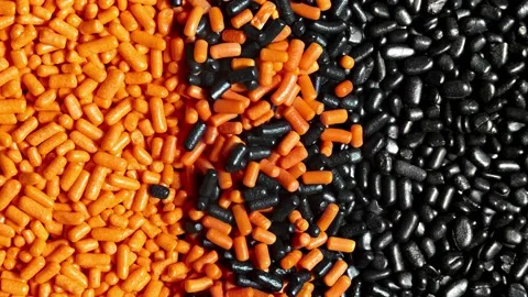 Halloween themed background, orange and black sprinkles are mixed together Stock Footage 136977038